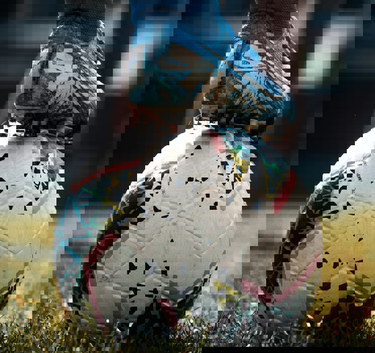 Fodboldstøvler der hviler på en fodbold